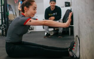 Een personal trainer die een fitnessklant traint in de sportschool.